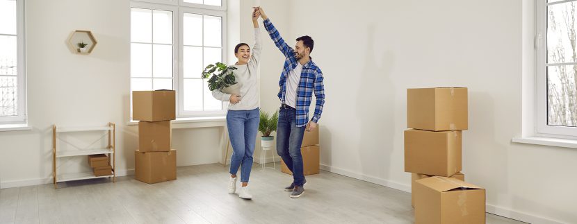 Happy Young Family Couple Having Fun In Their Empty New House Or