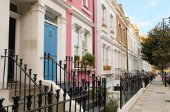 Typical Victorian terraced houses in England. Exterior view of cozy residential buildings in London with metal fence, several floors, windows and front door with molding. Real estate, Living apartments.